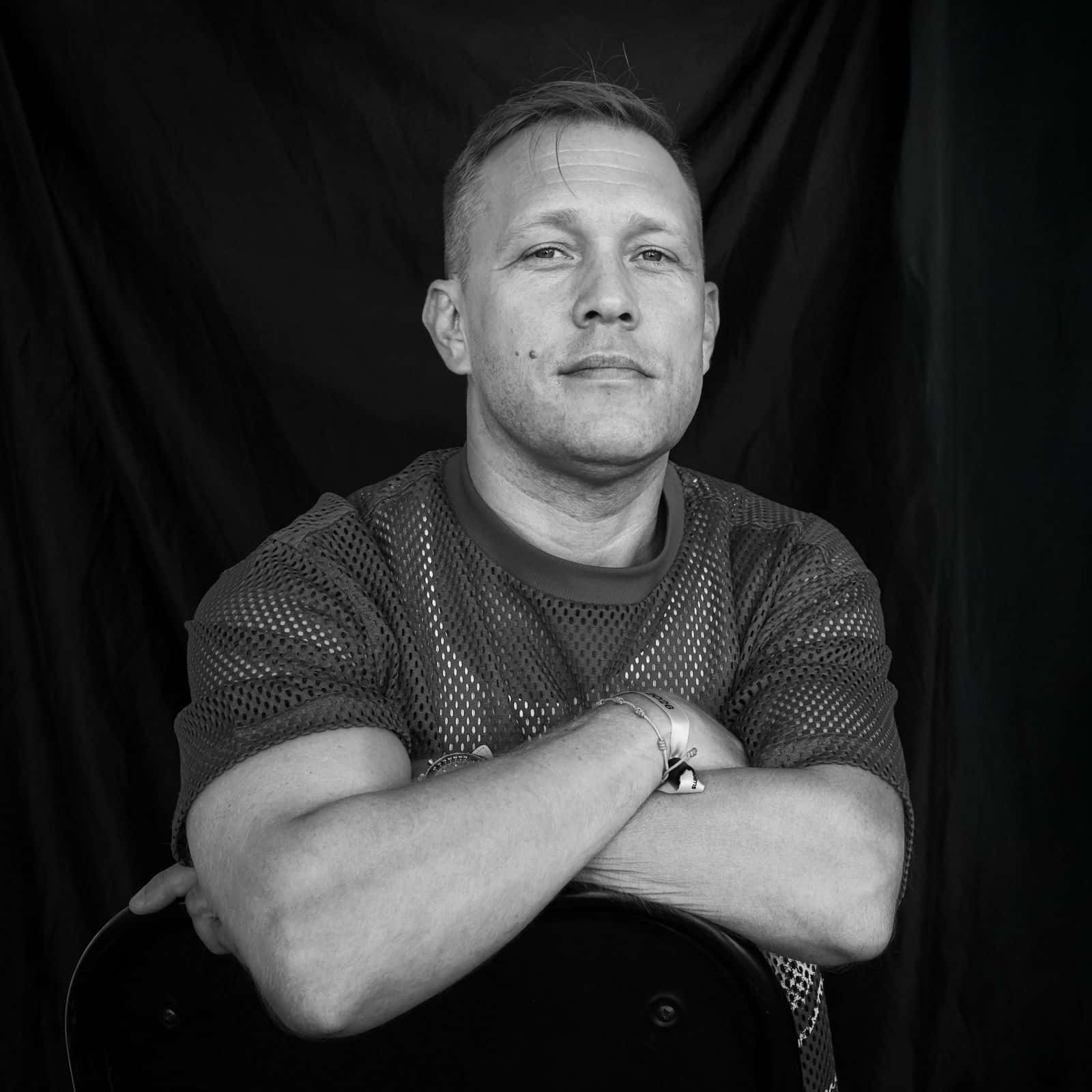 Porträtt av konstnären  Johannes Gustafsson mot svart bakgrund