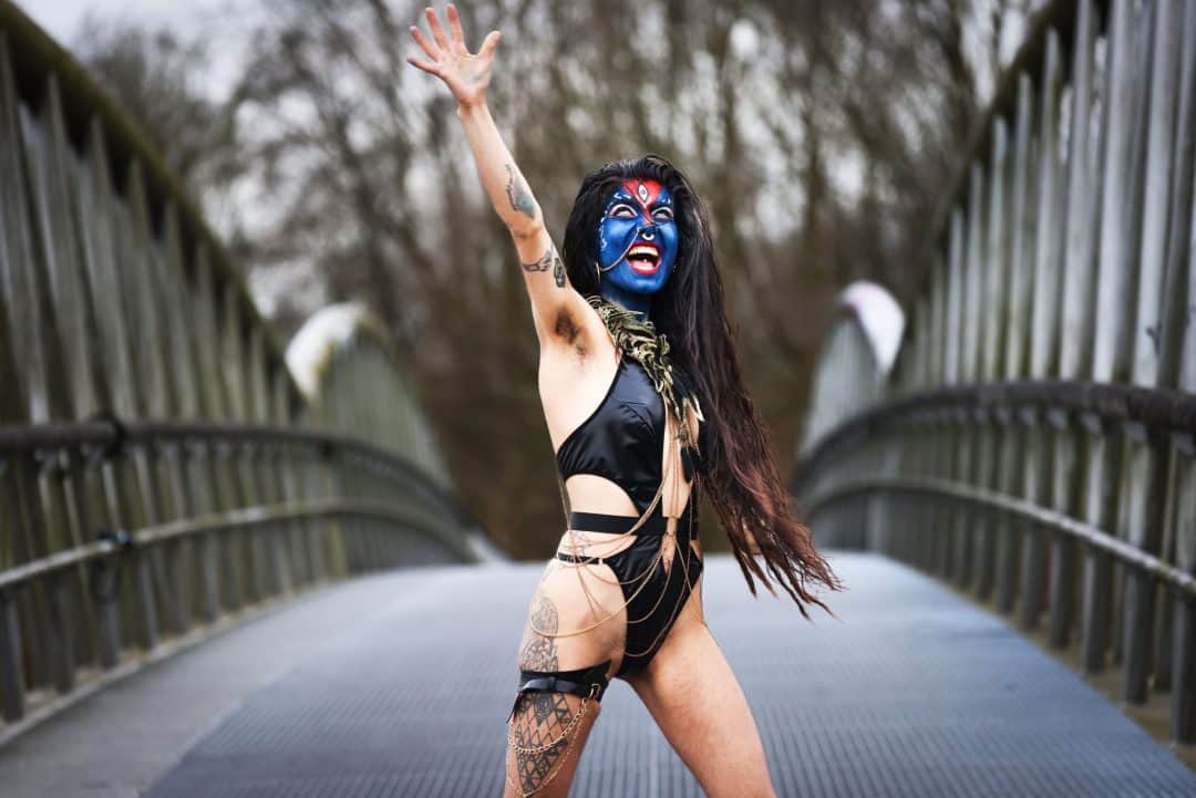 Kali—the goddess who asks for no permission. A fine-art photograph capturing a sensual, organic, and unposed moment with a single subject. The image emphasizes a raw, intimate vulnerability, as if all masks have been removed.