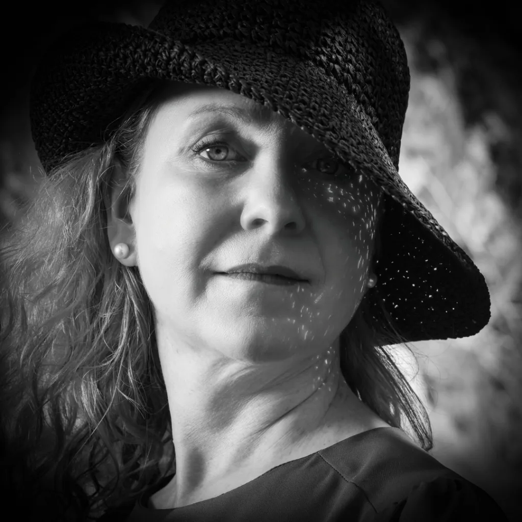 Beautiful woman in hat. The picture taken in the shade with a reflex screen