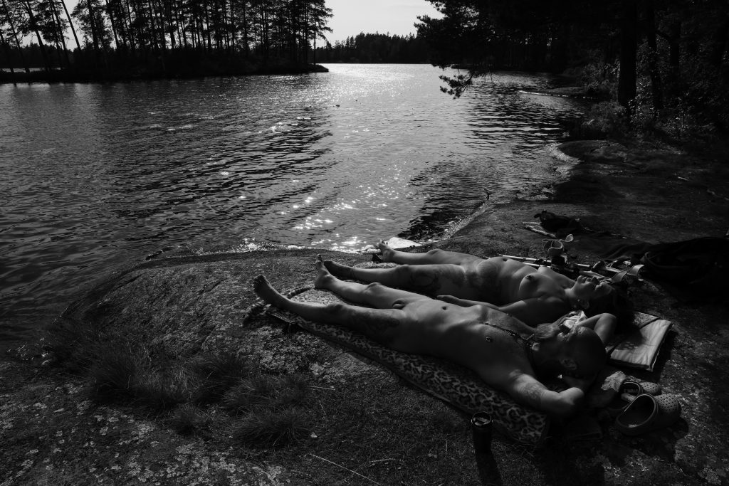 Naked man and woman sunbathing at Björndammen in Sweden